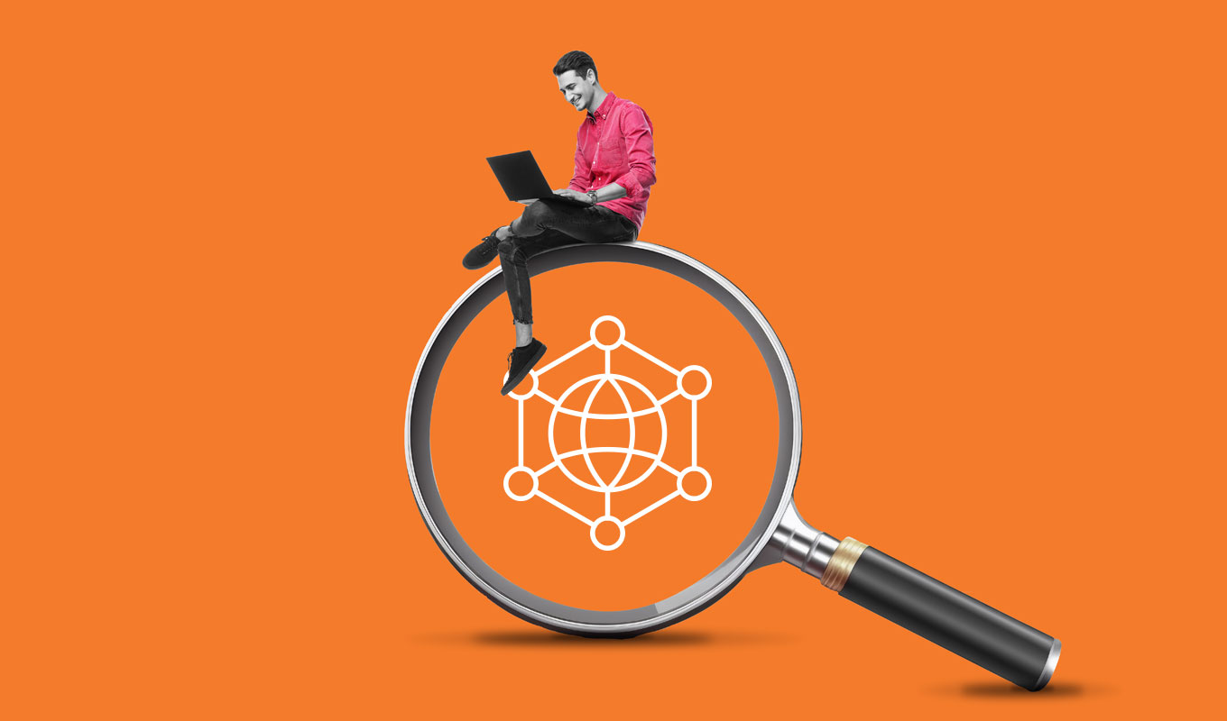 Man with laptop sitting on magnifying glass with web icon in center